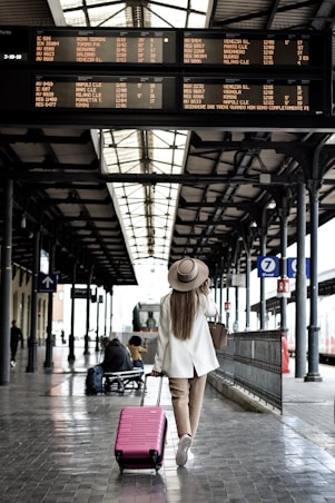 woman holding pink luggage