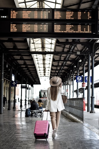 woman holding pink luggage