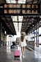 woman holding pink luggage