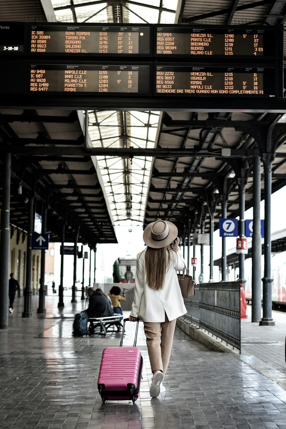 woman holding pink luggage