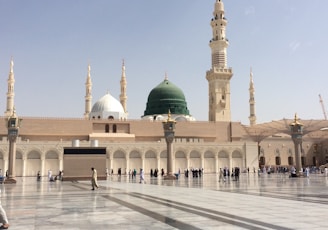 people walking outside a dome mosque building