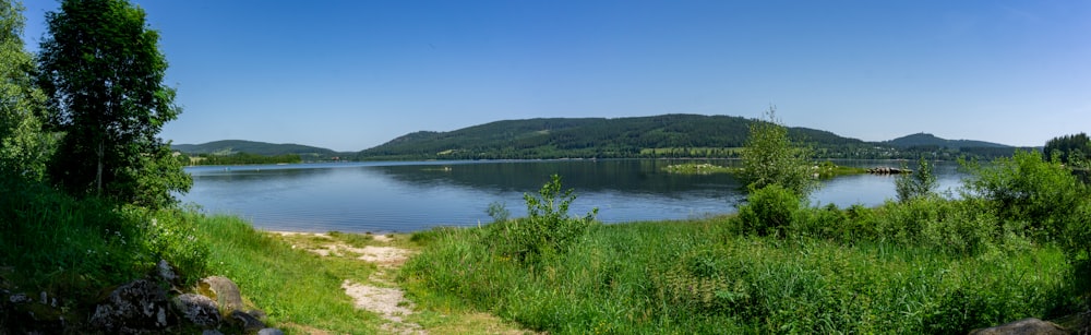 body of water viewing mountain under blue and white sky during daytime