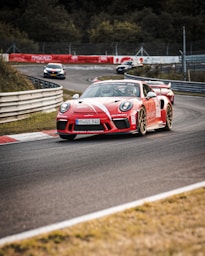 red and white coupe racing on road during daytime