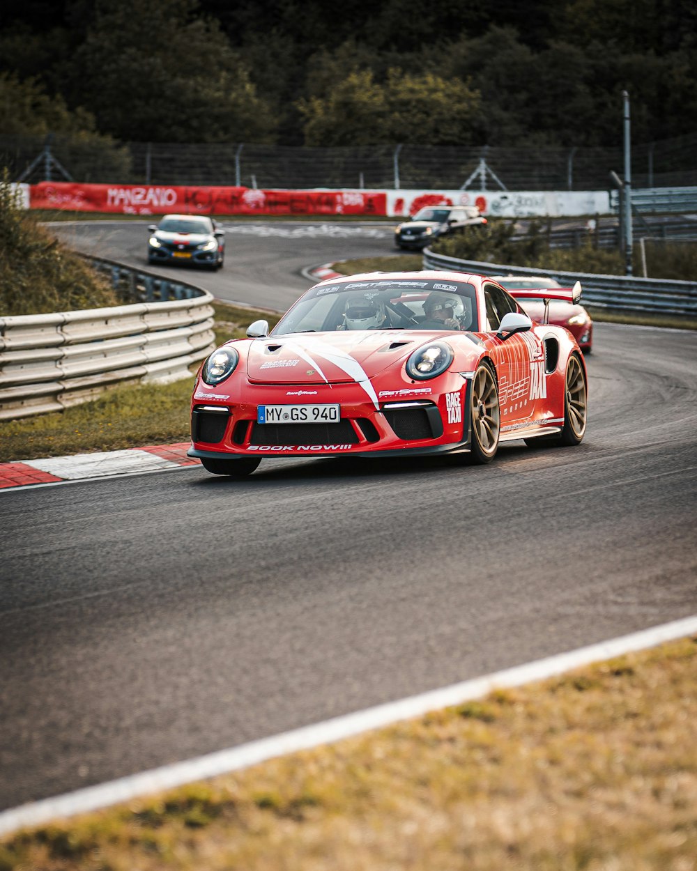 red and white coupe racing on road during daytime