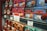 Rows of colorful vintage-style tin boxes are displayed on shelves, each containing La Mere Poulard butter cookies. The packaging features intricate designs and illustrations, emphasizing a traditional and artisanal product. Prominent signage with pricing and promotional offers is visible, indicating a special sale.