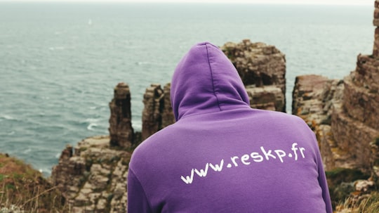 person sitting in front of calm body of water in Cap Fréhel France