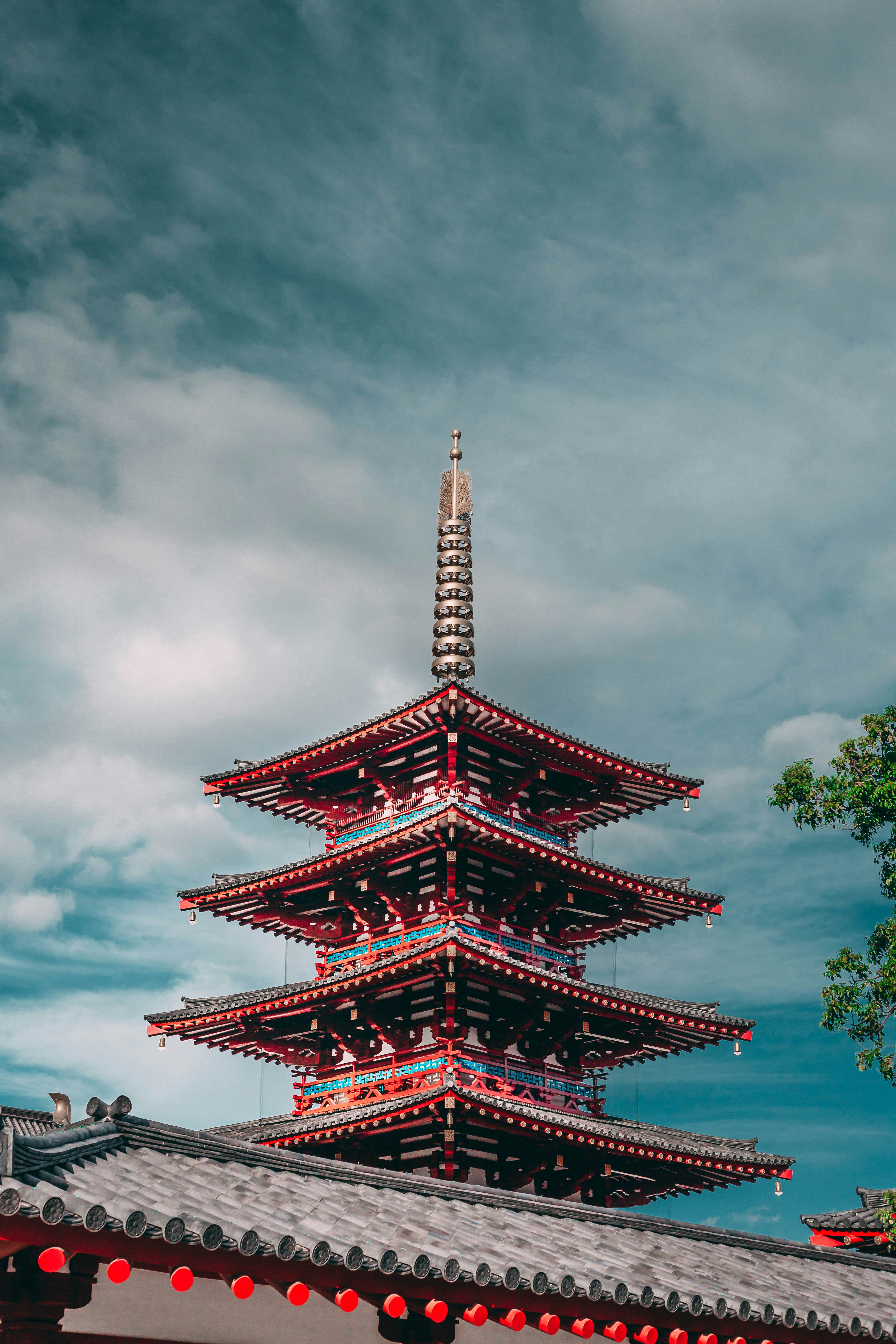 red and blue pagoda under a cloudy sky