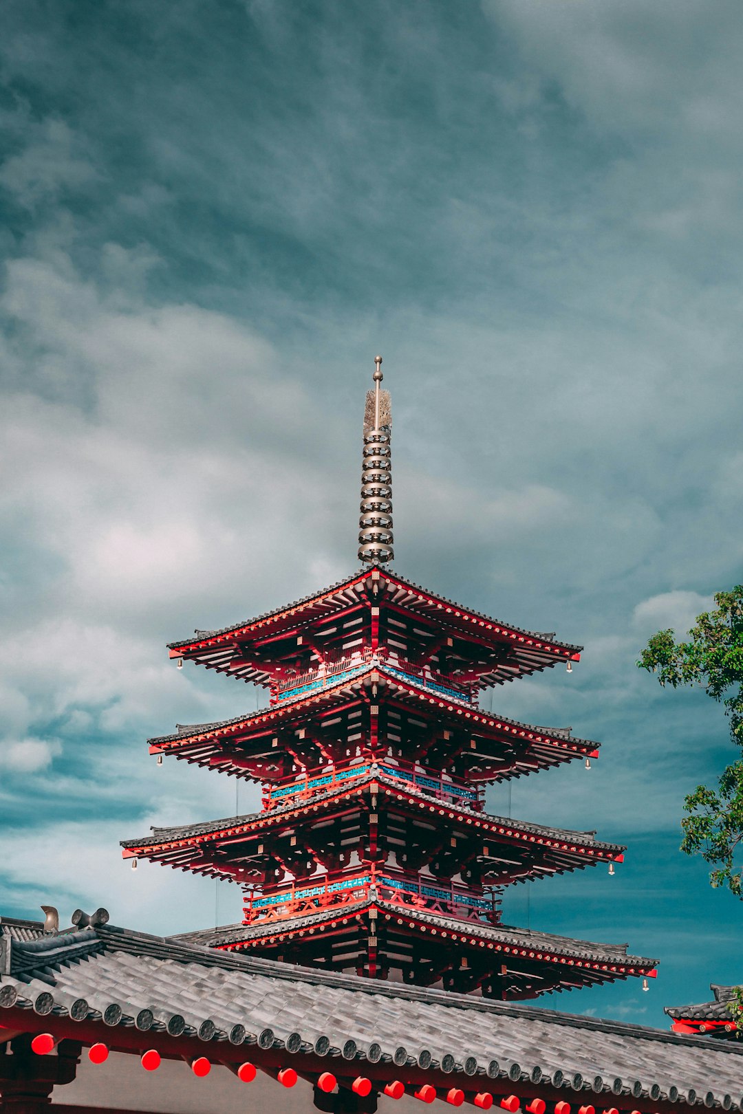 red and blue pagoda under a cloudy sky