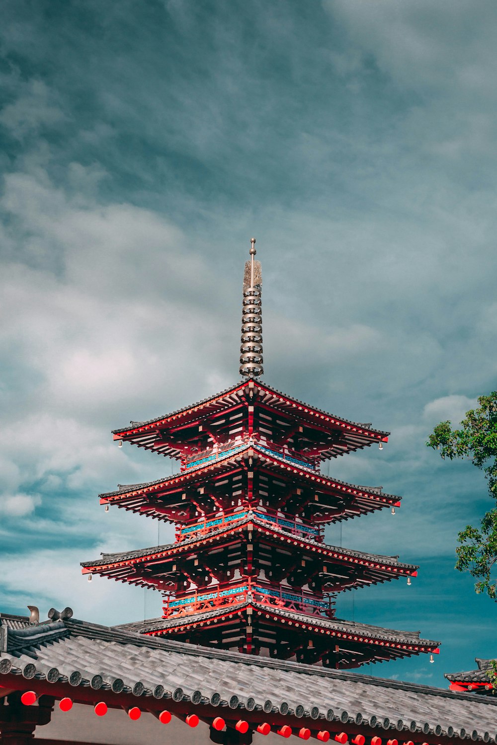 red and blue pagoda under a cloudy sky