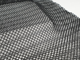 Various mesh samples showing different weave patterns and thicknesses laid out on a table.