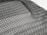 A detailed black mesh material with intricate patterns is laid out, displaying a grid of interlocking loops and open spaces. The texture appears flexible and lightweight, with subtle shadows adding depth.