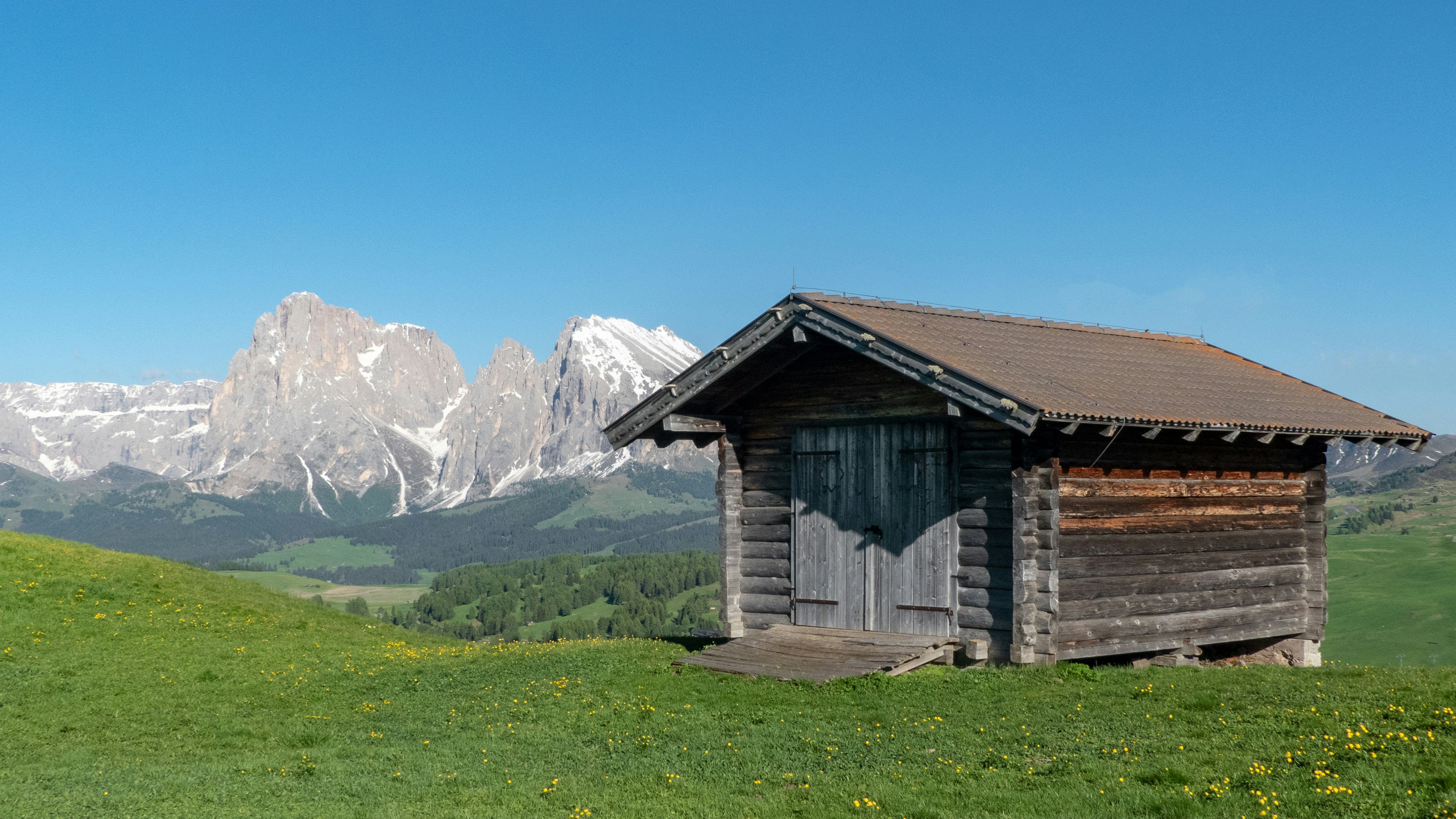 Brown Wooden Cabin On Green Field Under A Calm Blue Sky Photo