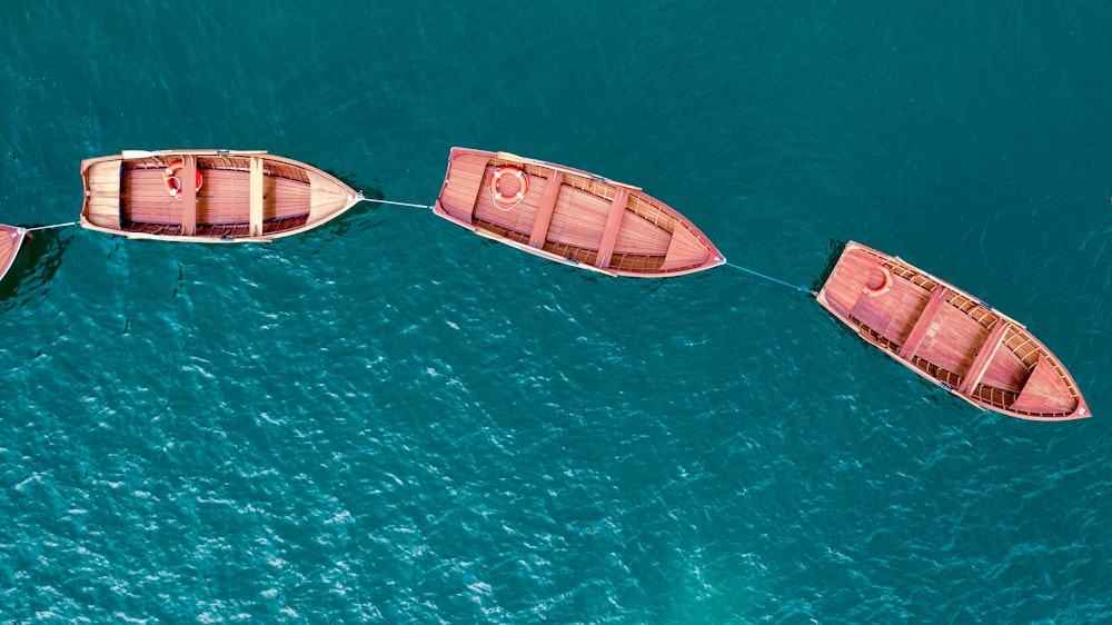 three brown boats on body of water during daytime