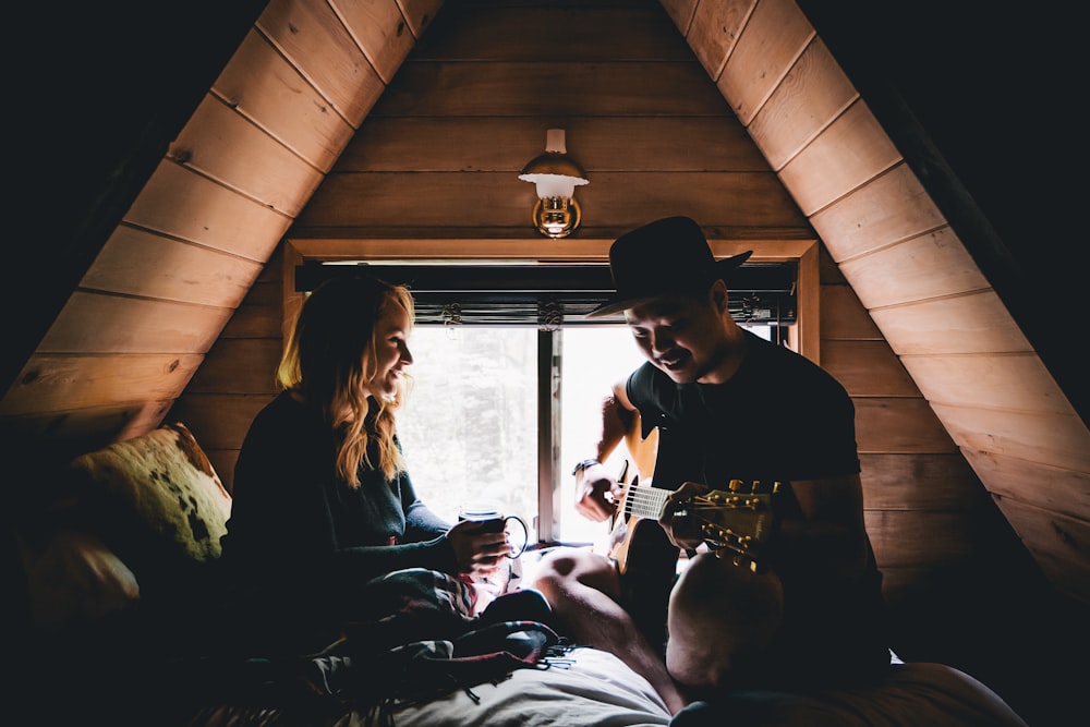 homme jouant de la guitare face à la femme