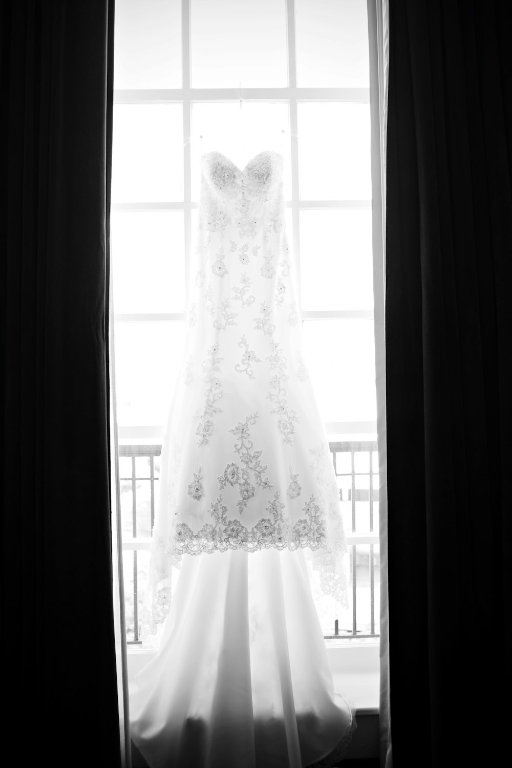 white floral wedding gown beside window