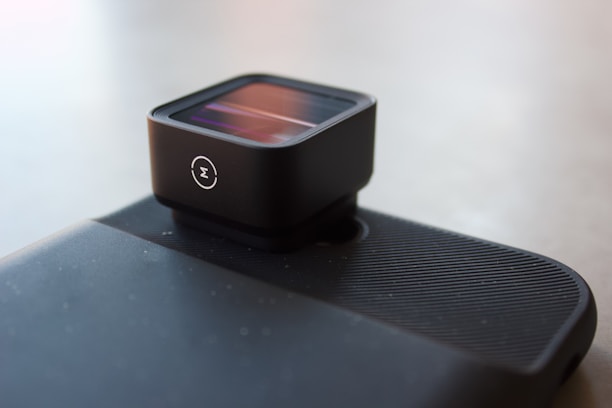 A sleek camera and lens setup displayed on a modern black and white surface with blue accents.