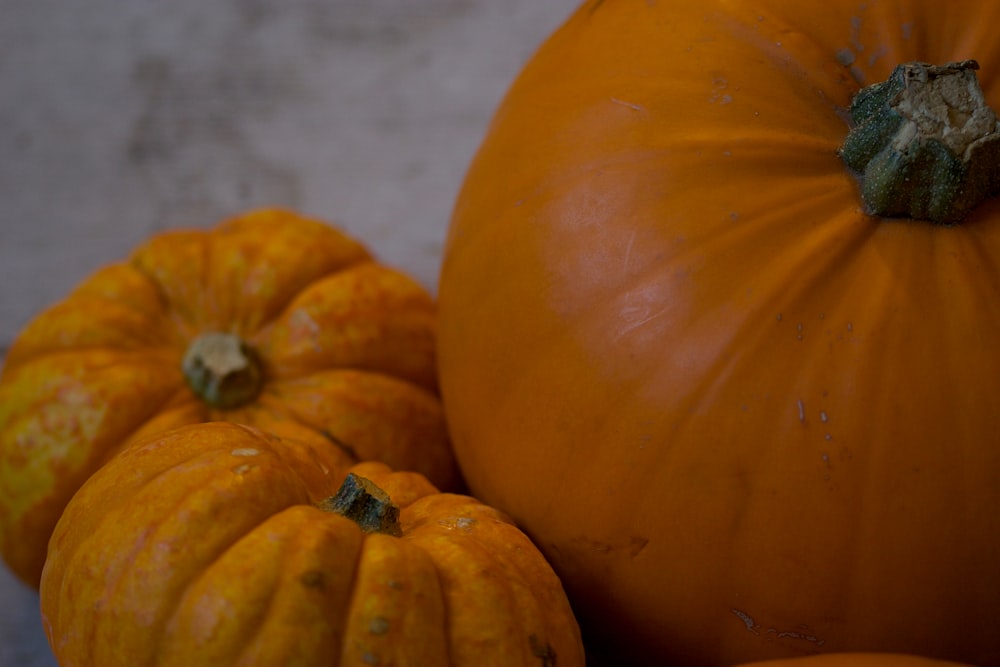 three pumpkins on white surface