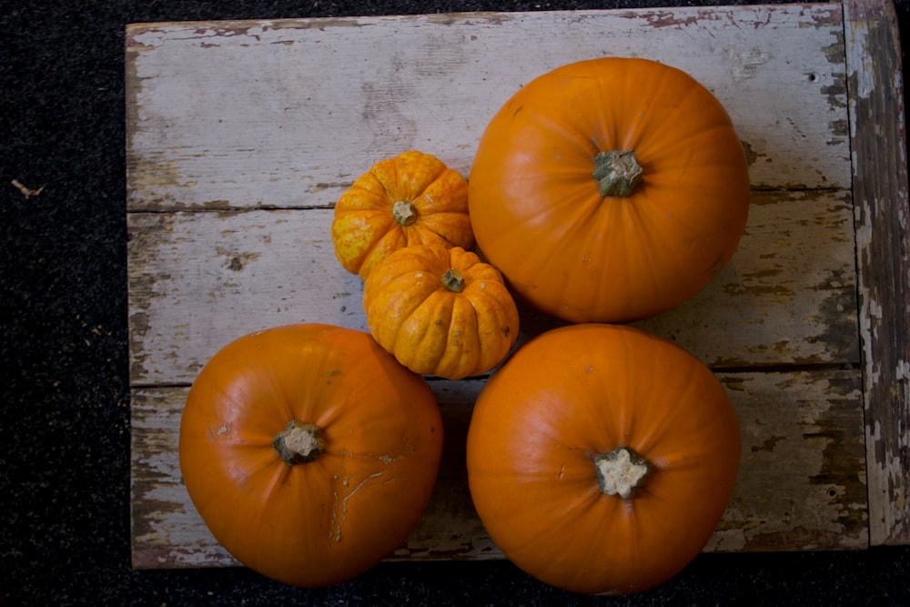 five pumpkins on white slab