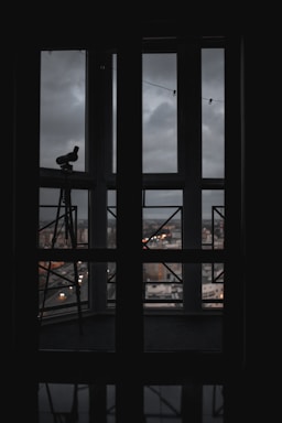 A cozy workspace with a telescope pointing towards the stars at dusk.