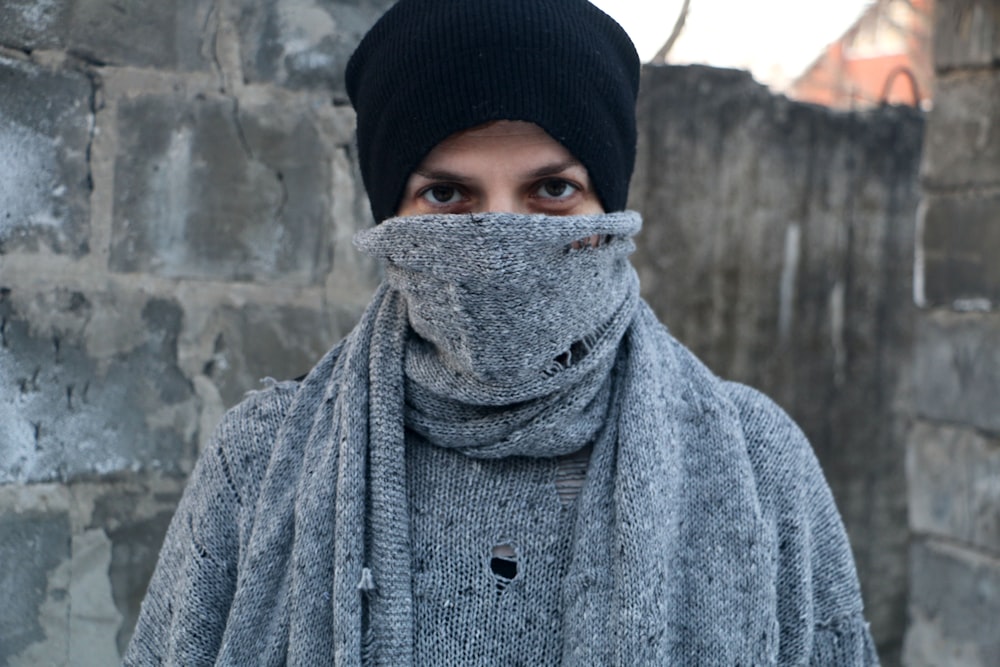 man covered his face by gray scarf