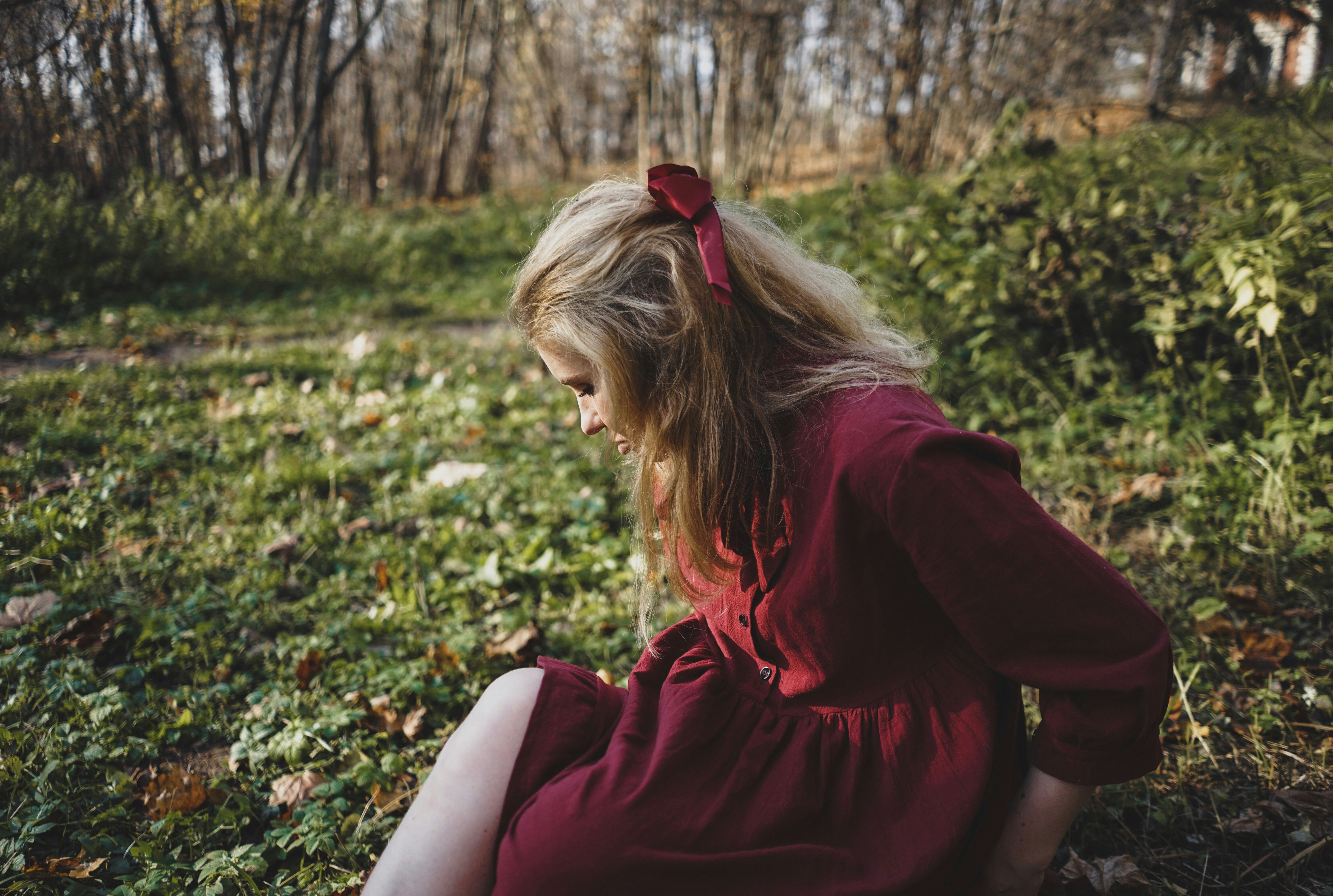 woman sitting on green grass field