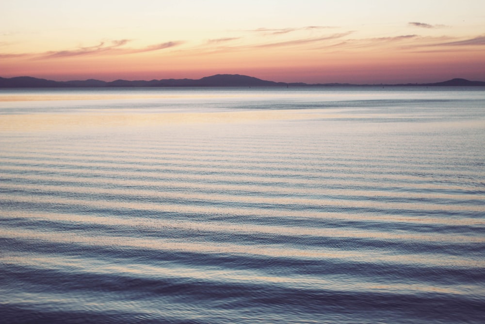 calm body of water during golden hour