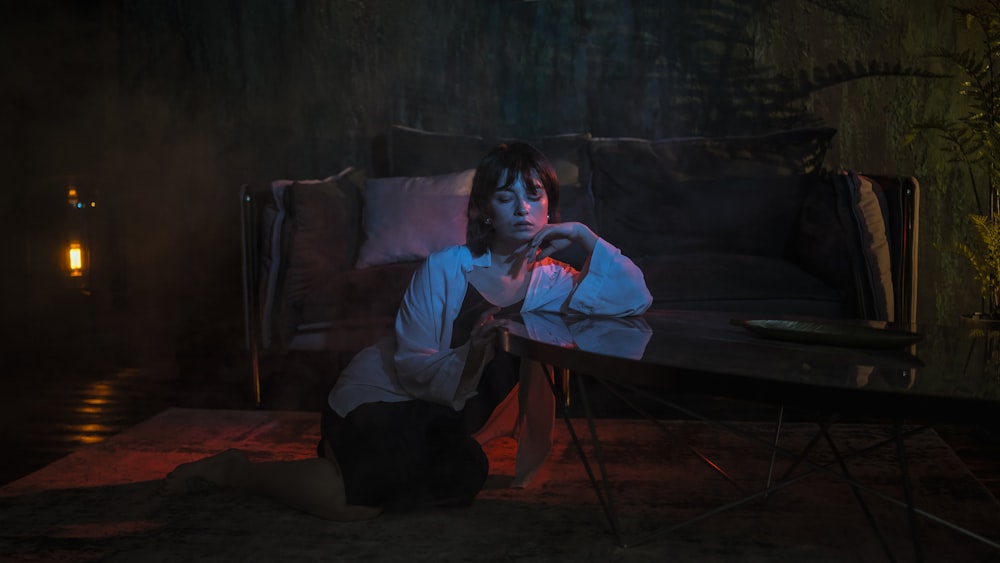 woman leaning on glass coffee table