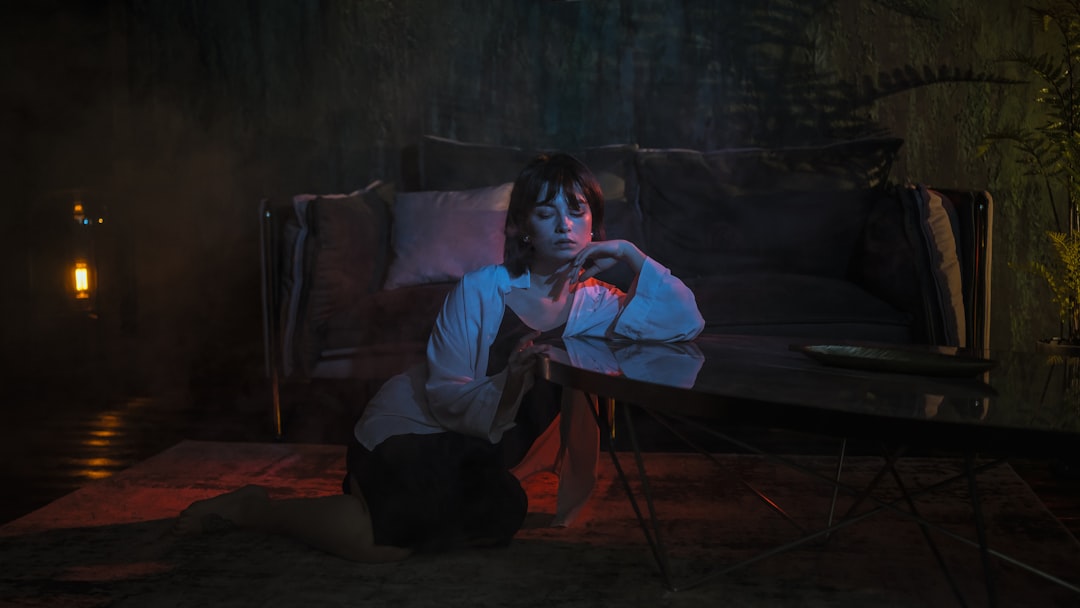 woman leaning on glass coffee table, Empty black hotel room and Maria in the middle of mistery