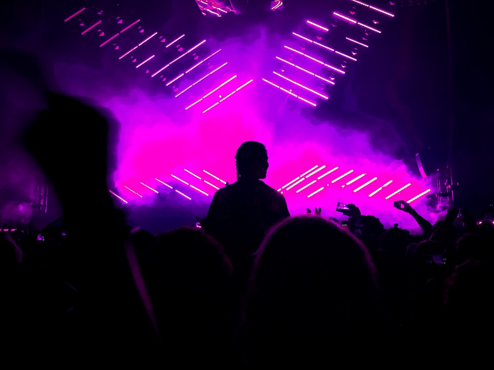 Silhouette de personnes près des lumières roses et violettes