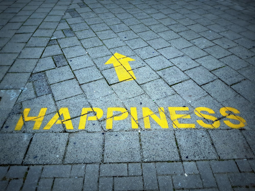 a brick sidewalk with a yellow arrow painted on it