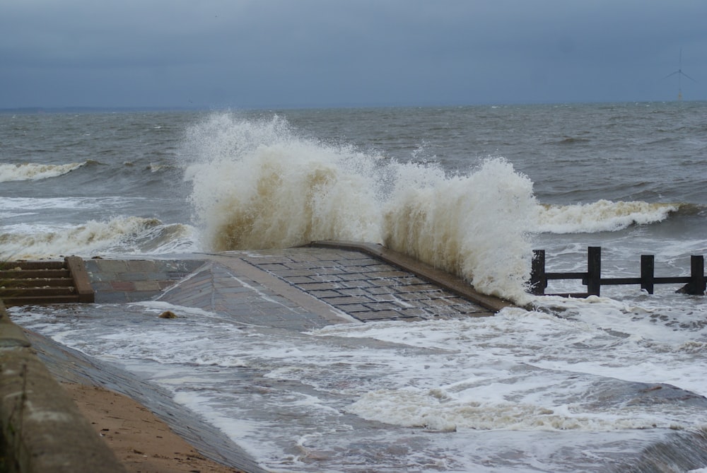 time lapse photography of waves splashing on seawall