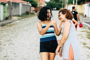 Friends laughing together on a cobblestone street in a charming old town