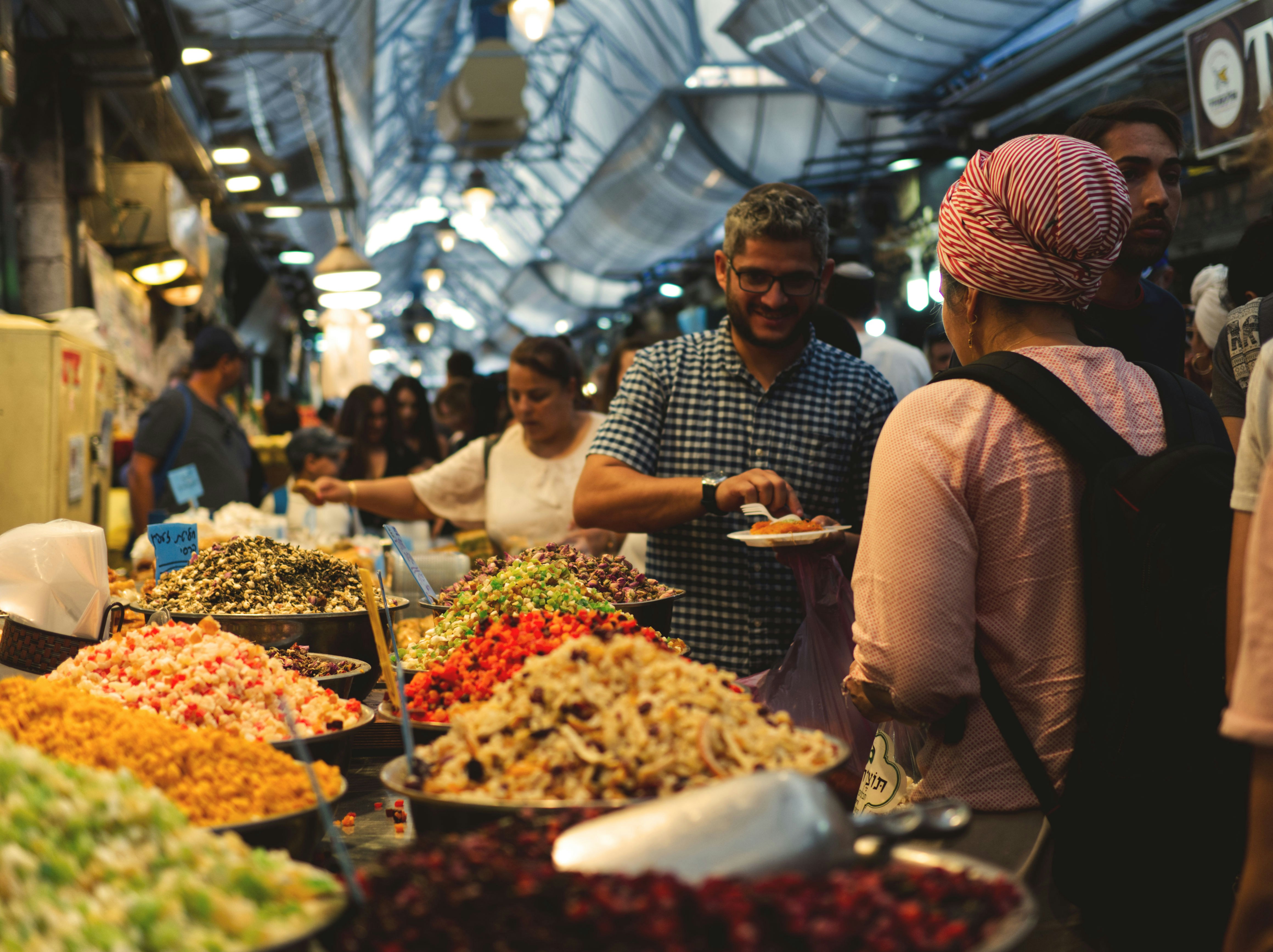 people walking and standing beside food and spices