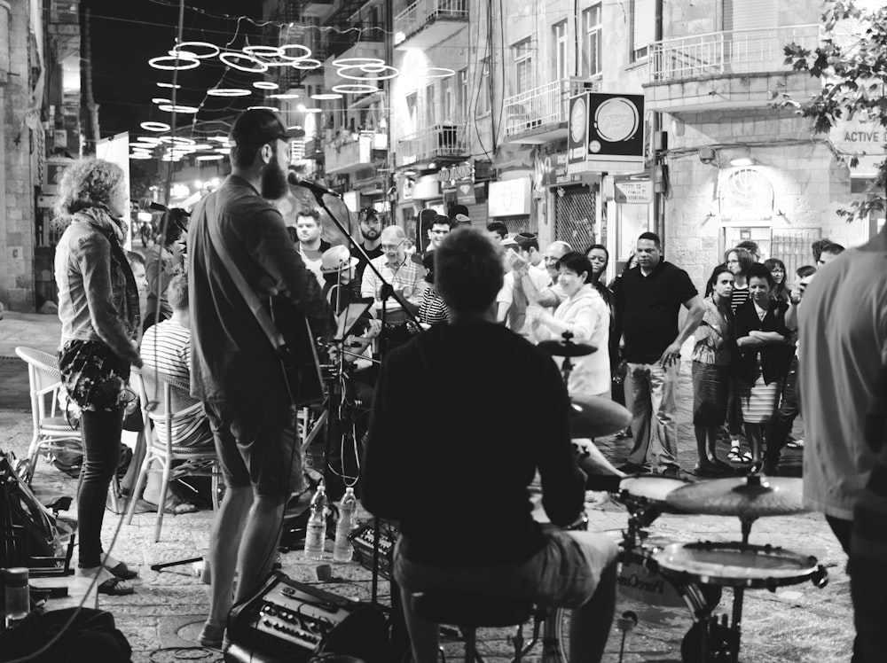 grayscale photo of people performing on street