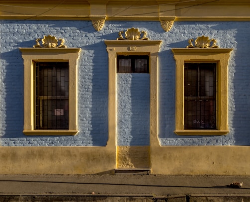 Close-up of a newly restored facade with clean lines and fresh blue paint under bright sunlight.