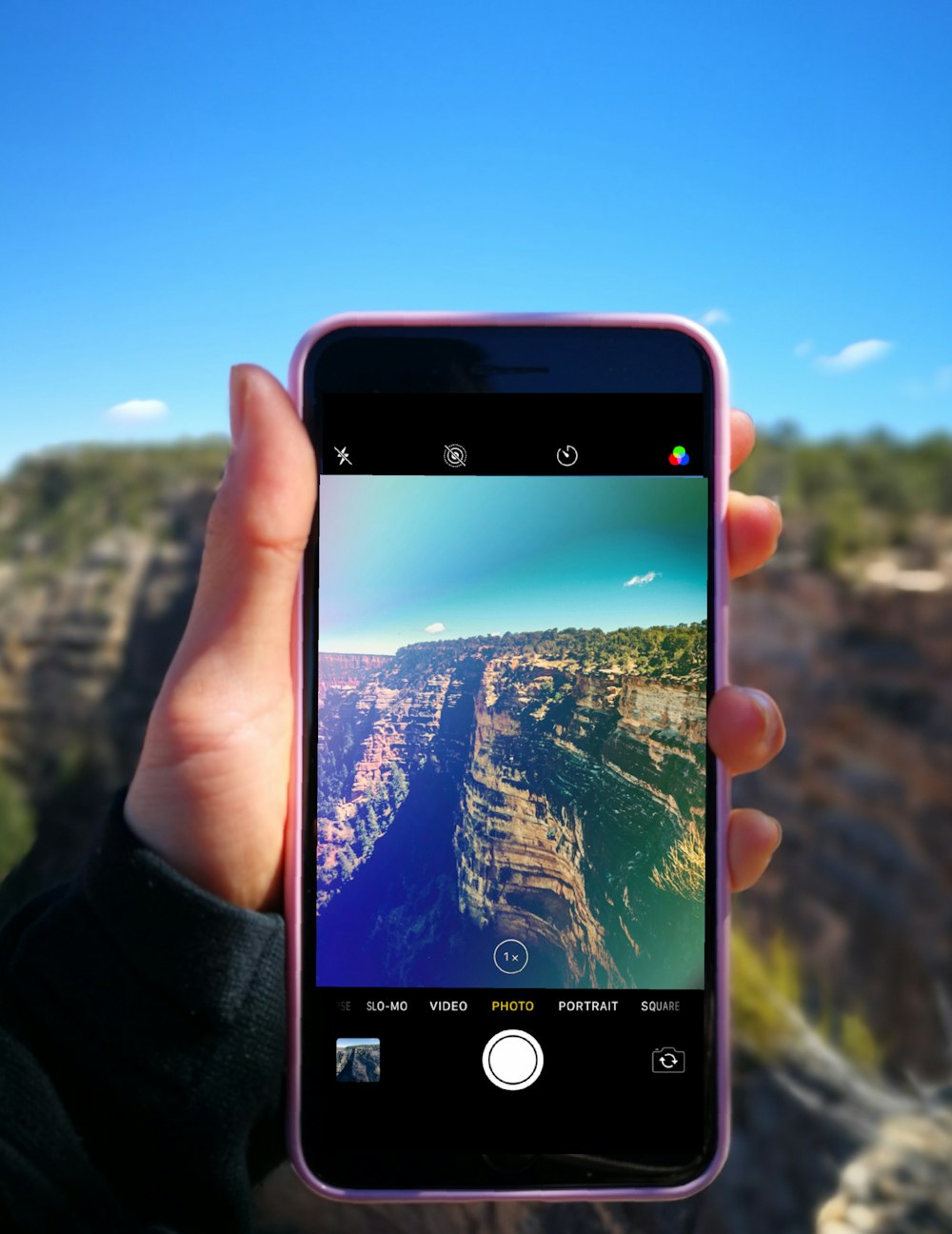 person taking photo of hill during daytime