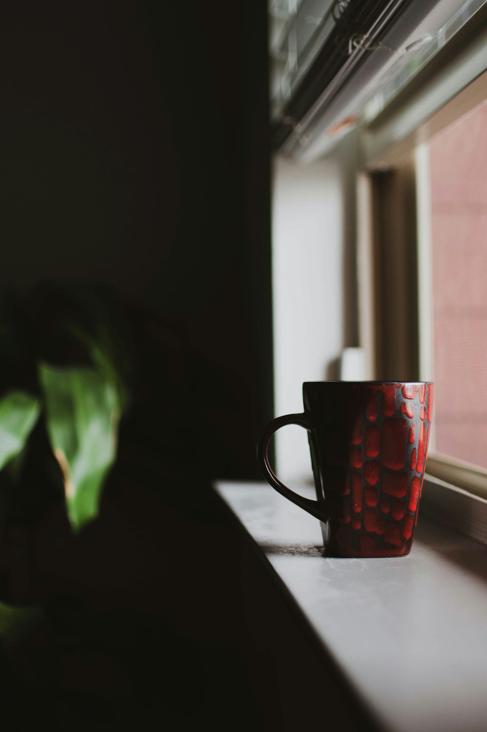 red mug near window