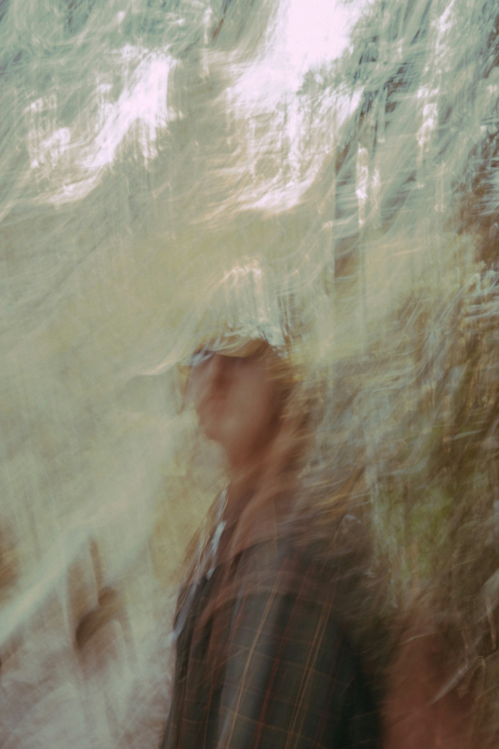 a blurry photo of a man standing in front of a tree