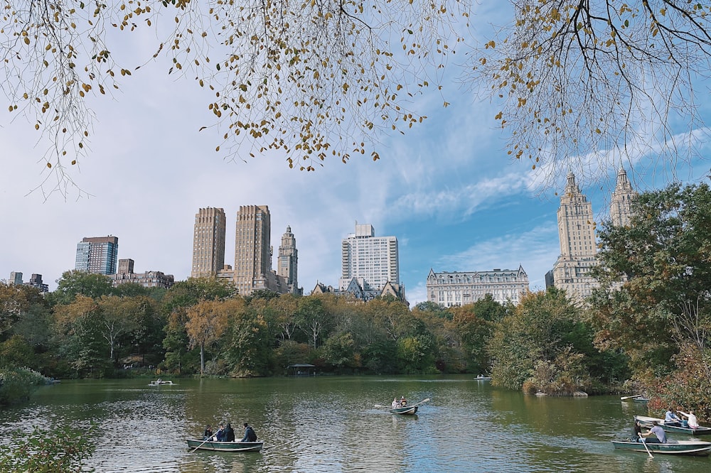 group of people rowing on boat on calm body of water