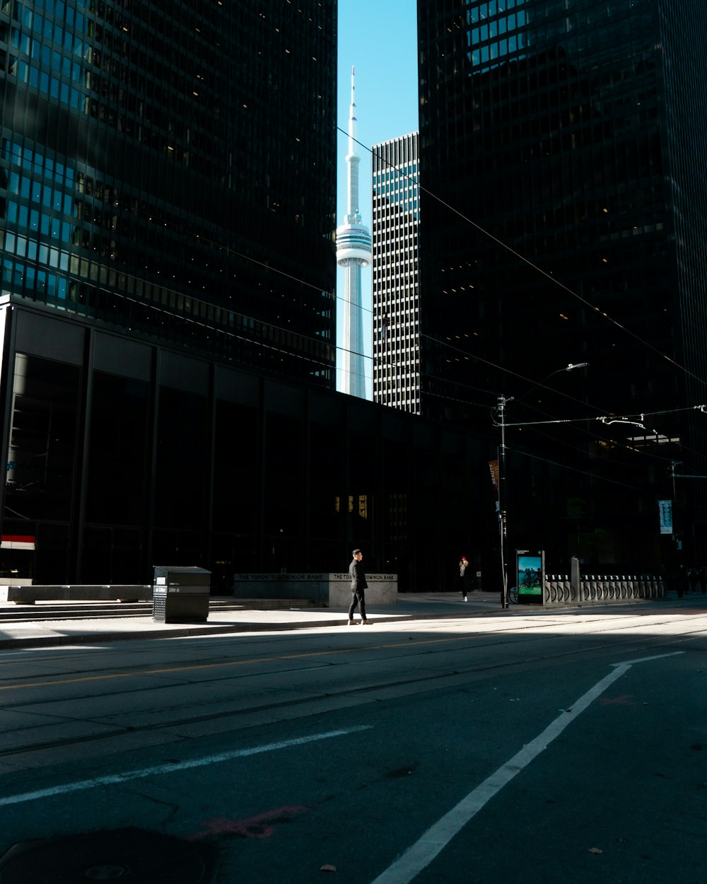 man wearing black jacket walking on street