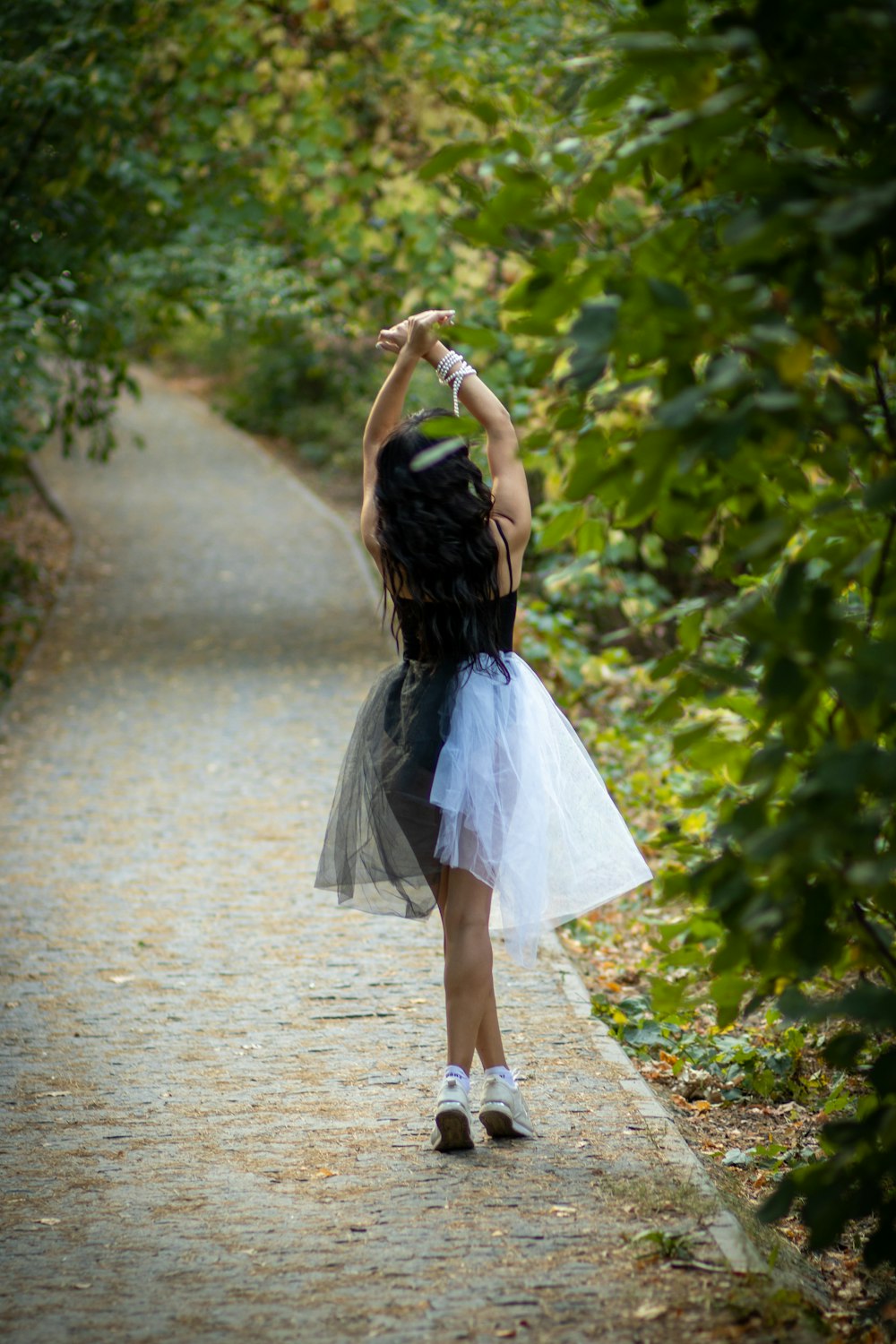 woman standing on pathway between plants