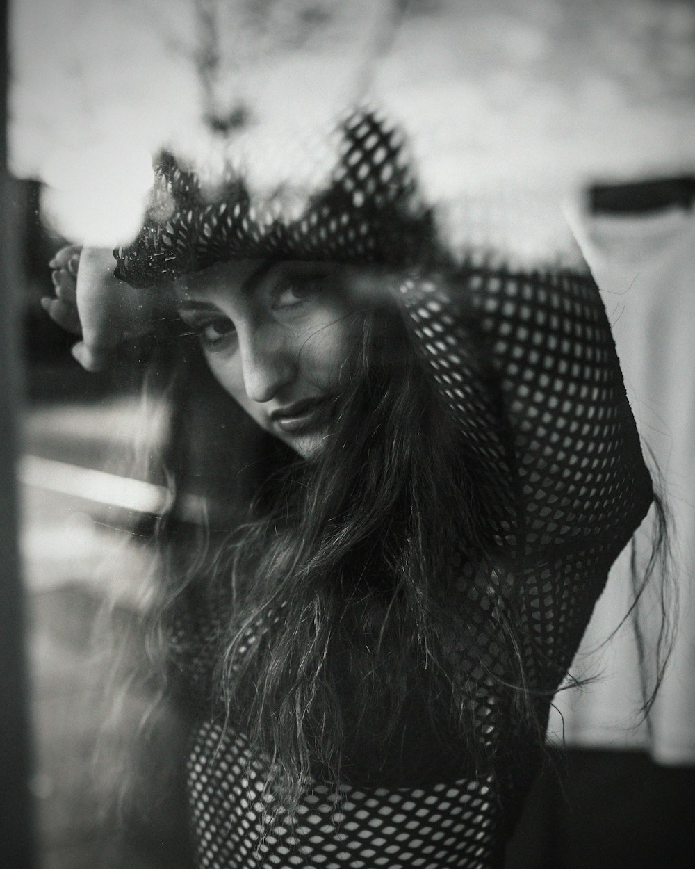 grayscale photography of woman on window