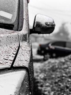 A close-up of water droplets on a freshly washed car surface.