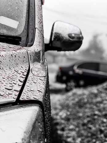 A close-up of water droplets on a freshly washed car surface.