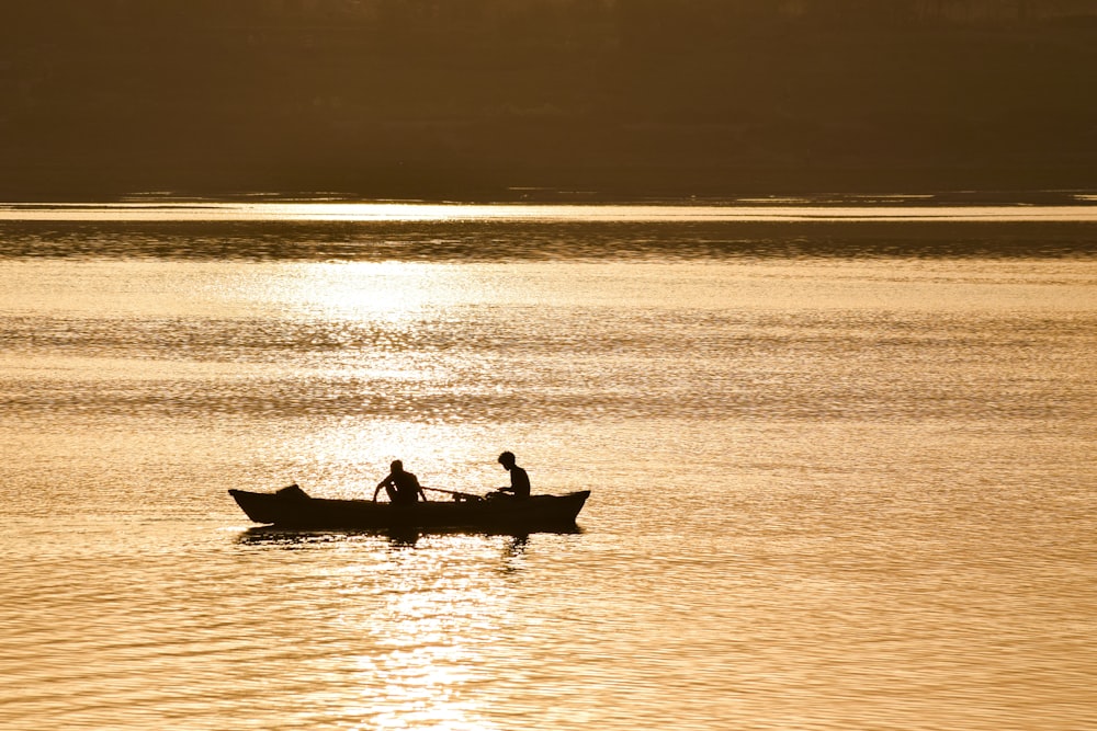 silhouette of two person on boat
