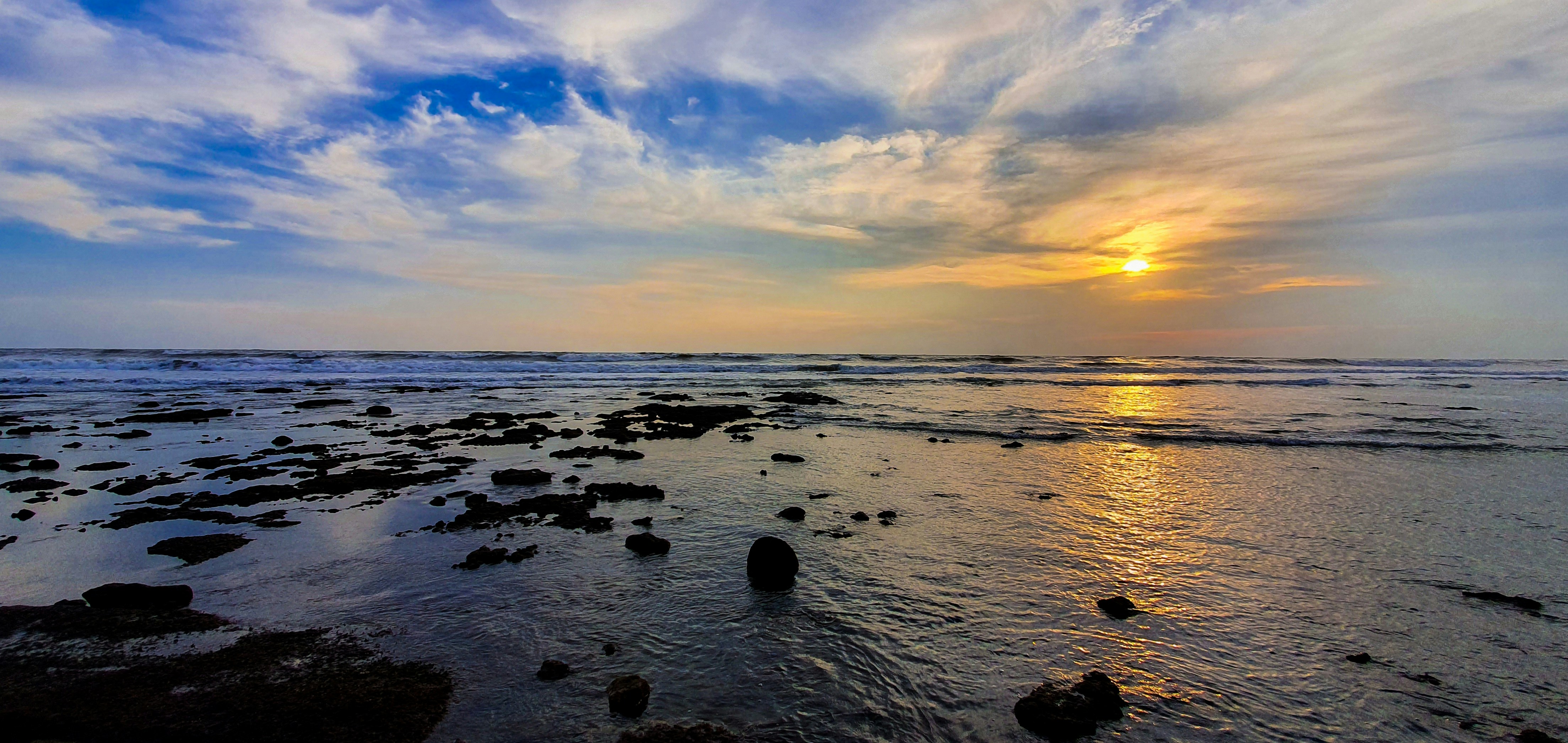 silhouette of stones and body of water under gray and white clouds, Smell the sea, feel the sky. 