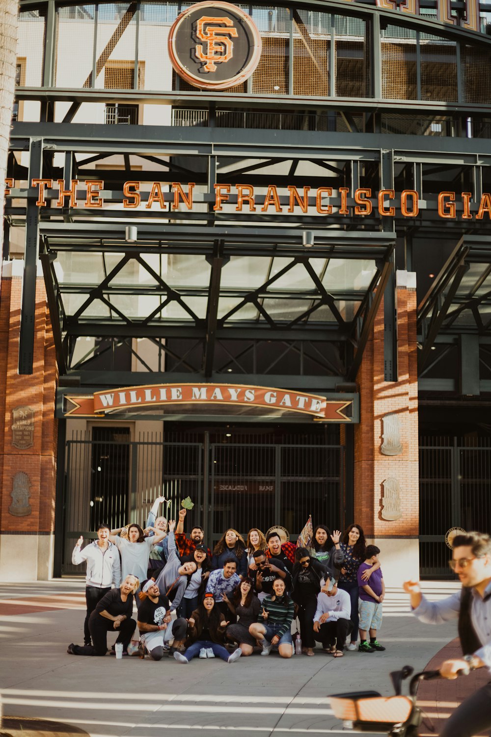 a group of people posing in front of a san francisco giants stadium