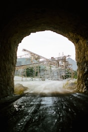 Dark-themed image of quartzite mining site with heavy machinery under moody lighting.