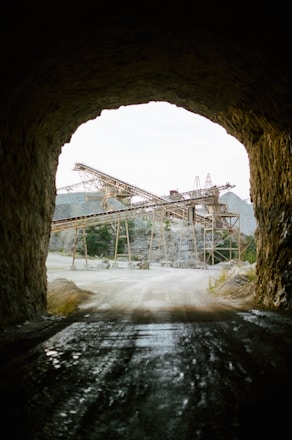 Dark-themed image of quartzite mining site with heavy machinery under moody lighting.
