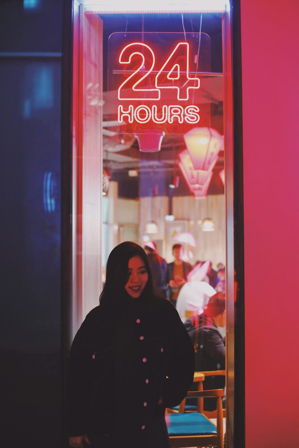 woman near 24 hours neon sign